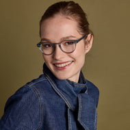 
A person is wearing shiny aqua round frames with clear lenses.