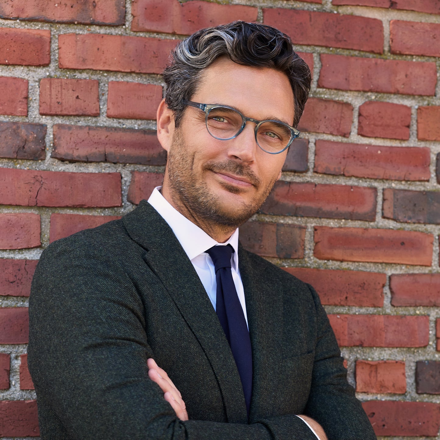 
A man wears shiny aqua round frames with clear lenses.
