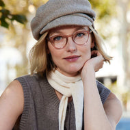 
A person wearing round shiny pink frames with clear lenses.