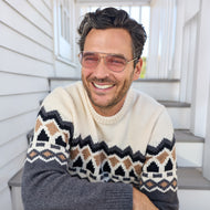 
A man wears gold aviator frames with pink tinted lenses.