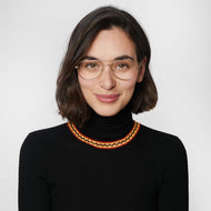 
A person wearing gold aviator glasses with clear lenses.
