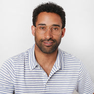 
A person is wearing gold aviator glasses with clear lenses.