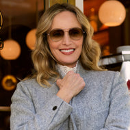 
A woman wears shiny rose gold aviator frames with brown gradient tinted lenses.