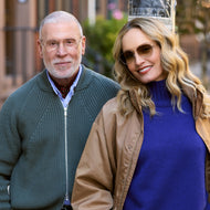 
A woman wears shiny rose gold aviator frames with brown gradient tinted lenses beside a man in clear-lens rose gold aviators.
