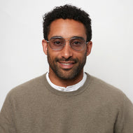 
A person is wearing silver blue tint aviator glasses with a shiny finish.