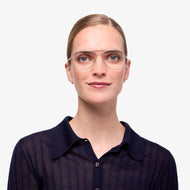 
Person wearing silver aviator glasses with a shiny finish and clear lenses.