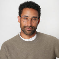 
A person wearing silver aviator glasses with clear lenses.