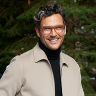 
A man wears translucent champagne square frames with clear lenses.