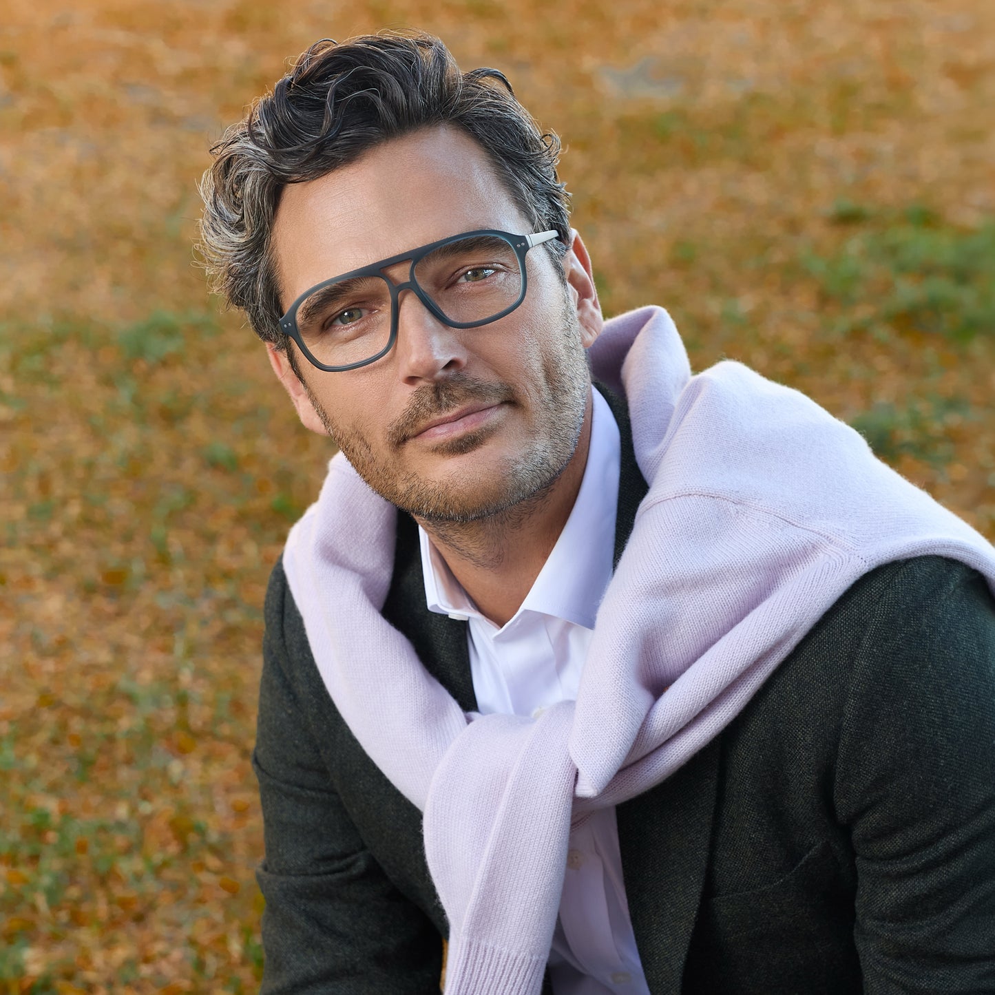 
A man wears lake blue rounded rectangular frames with clear lenses.