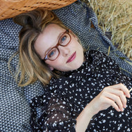
A person wears shiny cinnamon rectangular frames with clear lenses.
