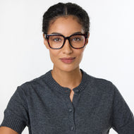 
A person is wearing shiny pink tortoise square frames with clear lenses.