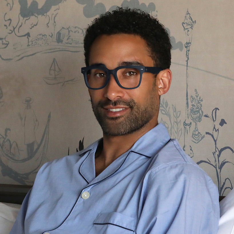 
Square navy frames with clear lenses worn by a person.