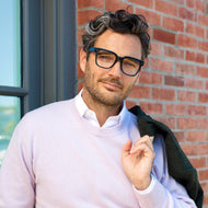 
A man wears shiny navy square frames with clear lenses.