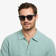 LA40XNAV10, LA40XNAV15, LA40XNAV20, LA40XNAV25 - Square navy frames with dark tinted lenses worn by a person.