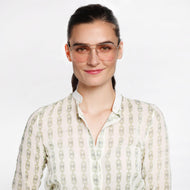 
A person wears square gold frames with pink tinted lenses.