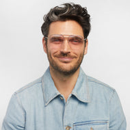 
A person wears square glasses with a gold frame and pink tinted lenses.