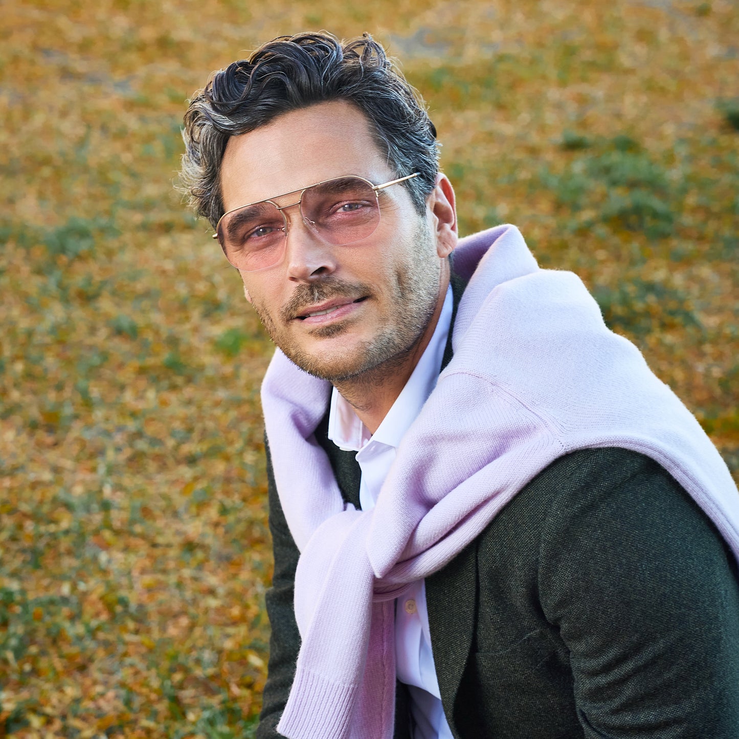 
A man wears gold metal frames with pink tinted lenses.