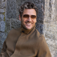 
A man wears shiny rose gold square metal frames with brown gradient tinted lenses.