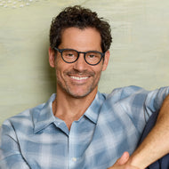 
Round black frames with clear lenses worn by a person.