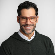 
A person is wearing square champagne coloured frames with a translucent finish and clear lenses.