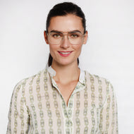 
Square gold frames with lightly tinted lenses worn by a person.