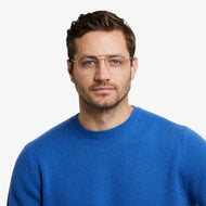 
A person is wearing square gold frames with clear lenses.